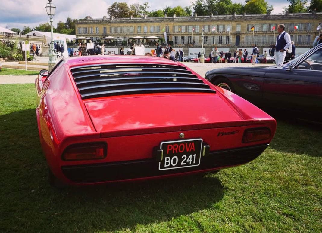 A red classic sports car at an elegant concours